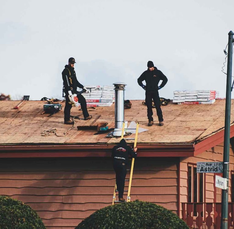 Roofing crew installing shingles on a residential home in Boise Idaho with foothills in the background