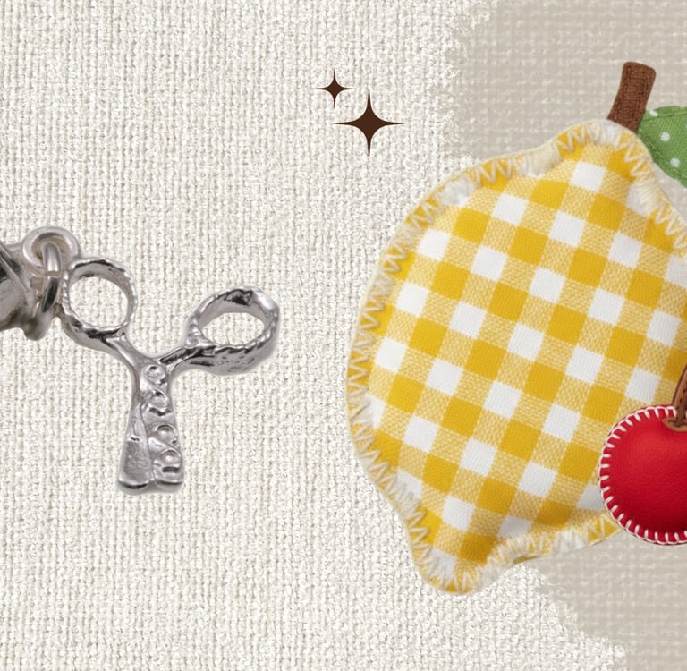 Silver thimble and scissors charm next to a yellow gingham lemon fabric patch.