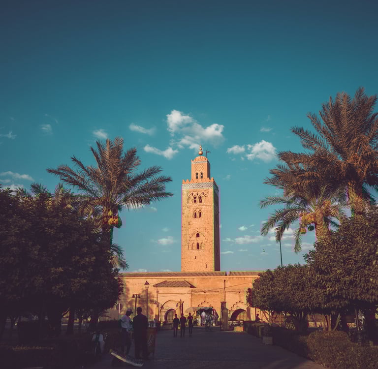 Koutoubia Mosque in Marrakech Morocco with palm trees and blue sky