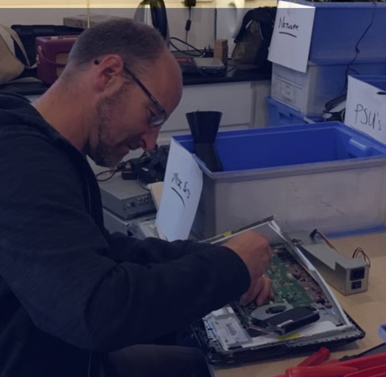 A TTB CircularIT employee disassembles a laptop to facilitiate responsible resource recovery