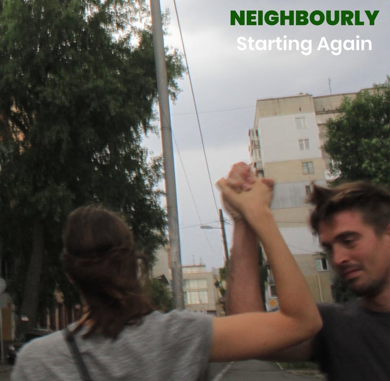 a man and a woman holding hands in the air in a hopeful way, smiling against an overcast backdrop.