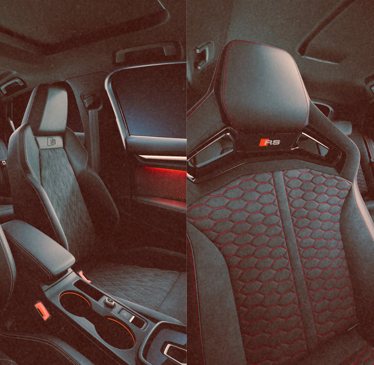 Luxury Audi RS sport seats with quilted leather upholstery and red stitching inside a modern car interior.