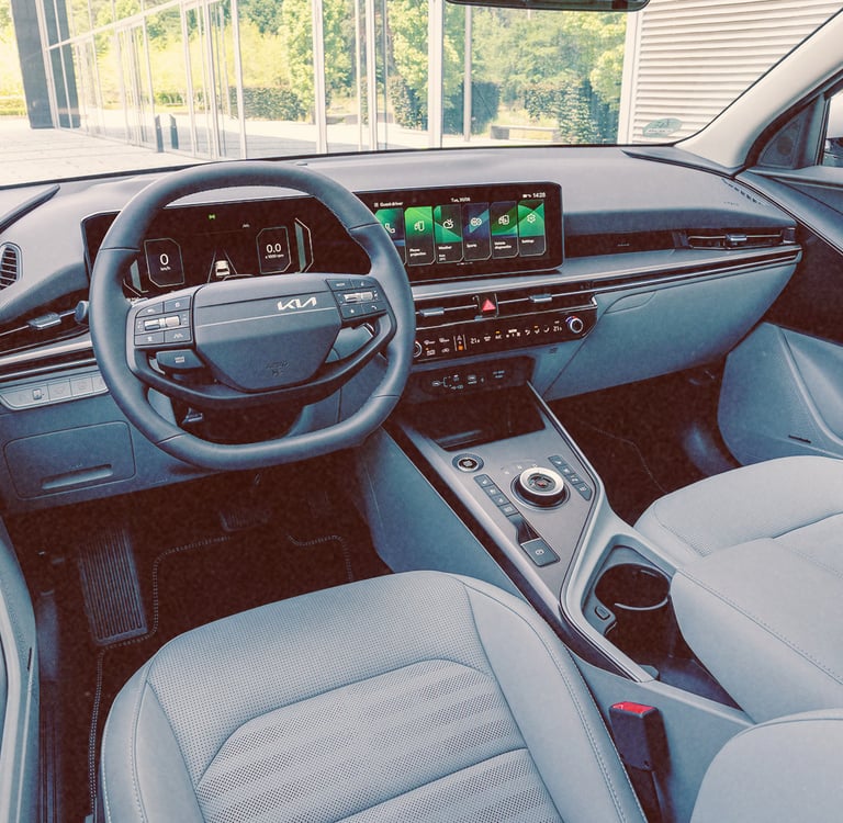 Modern interior of a Kia Niro car featuring a digital dashboard, touchscreen, and gray seats.