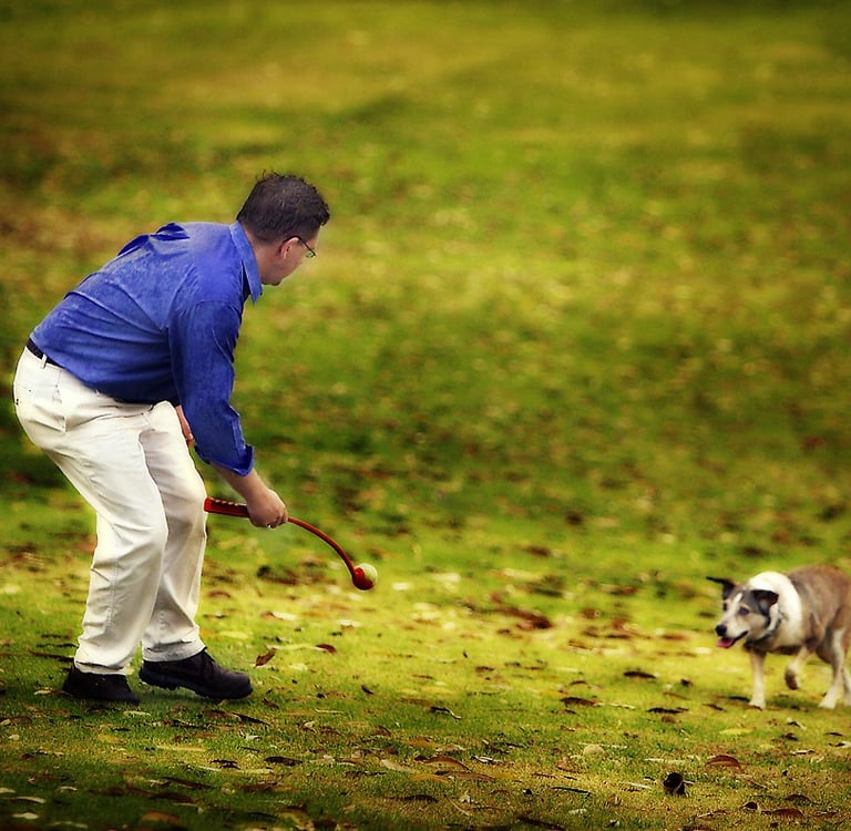 A man plays with his dog in a pet photo by Geoff Fisher