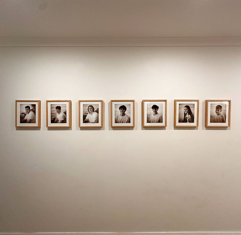 7 framed prints all in a row on the wall