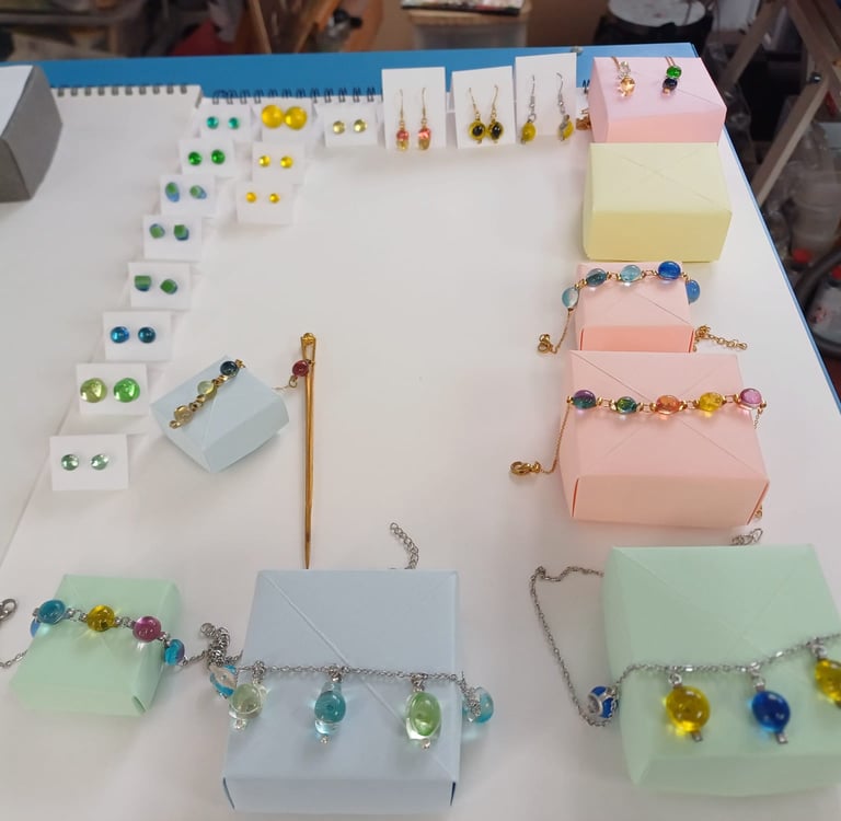 Sélection de bijoux artisanaux en verre et vitrail : bracelets et boucles d'oreilles colorés.