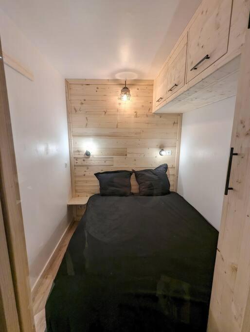 Cozy double bedroom in a Val Thorens ski apartment with warm lighting, alpine atmosphere and optimized sleeping space.