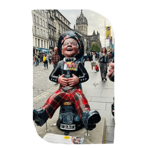 Oor Wullie statue wearing tartan trousers, holding his belly and laughing