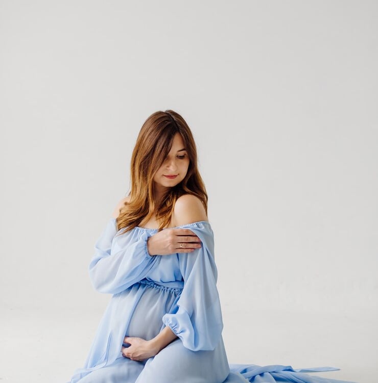 pregnant woman wearing blue background cleaning 