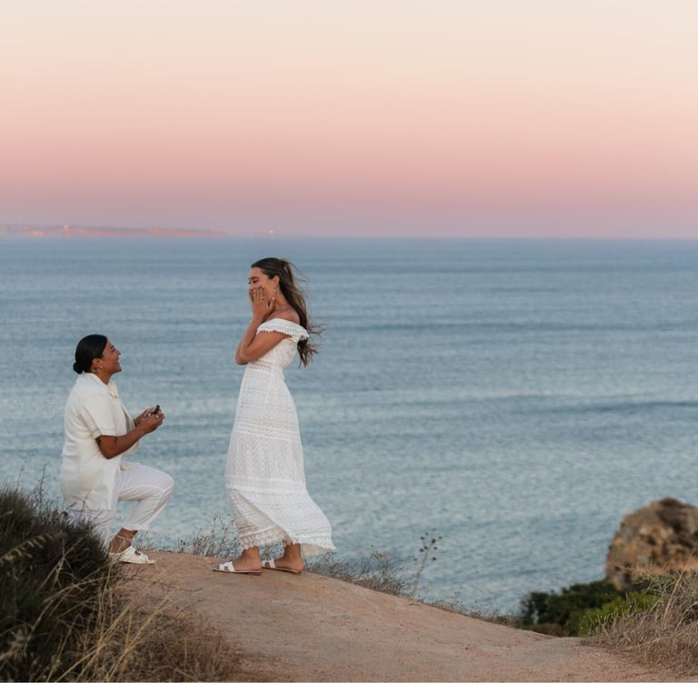 a man proposing a woman on a cliff overlooking the ocean