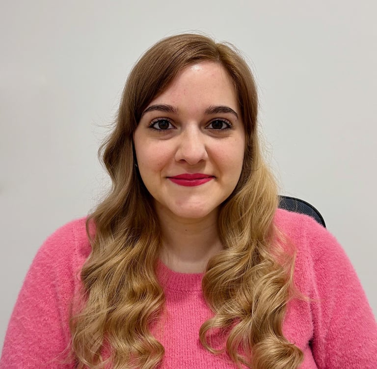 Fotografía de Fuencisla Martín. Mujer joven de pelo largo rubio, viste un jersey rosa