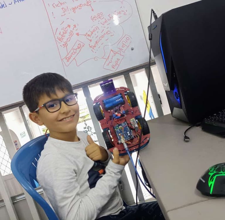 a boy sitting at a desk with a computer mouse