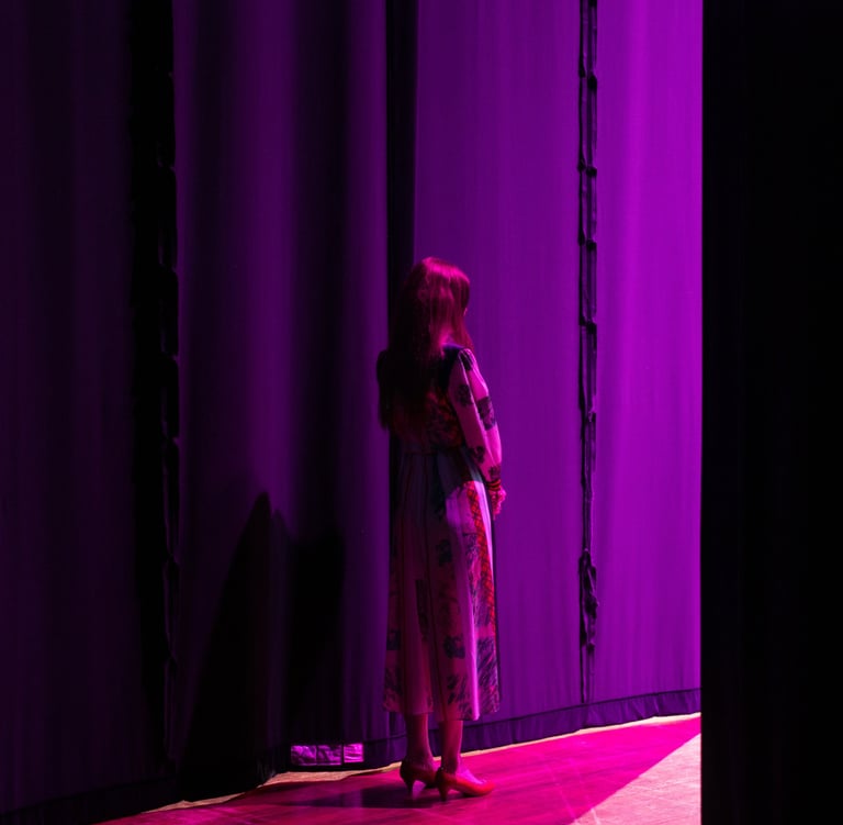 a woman standing in front of a purple curtain