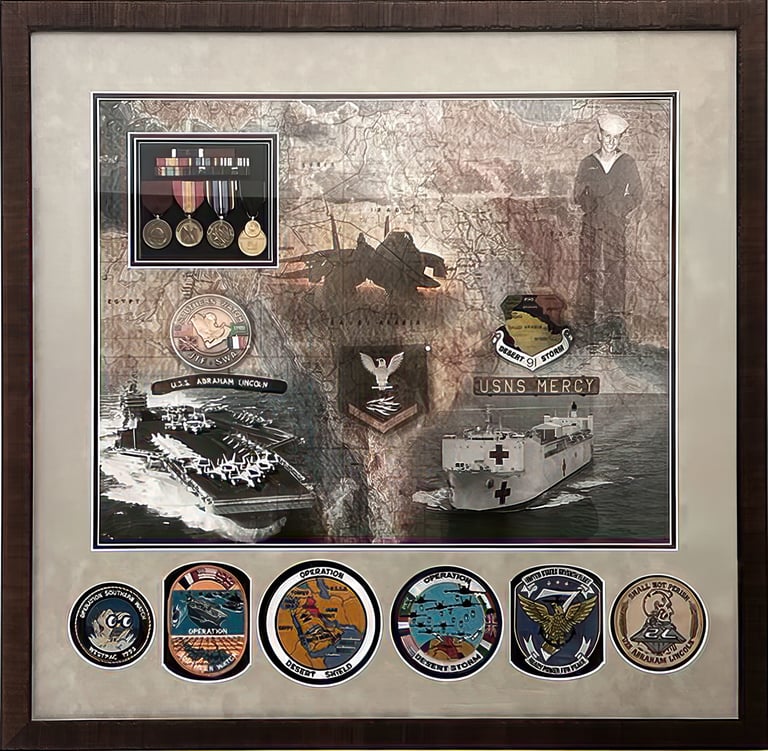 Framed Navy shadow box with military medals, patches, and photos of USS Abraham Lincoln and USNS Mercy.