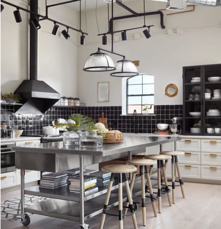 Modern residential kitchen featuring a mobile island with stainless steel benchtops and wooden bar stools.
