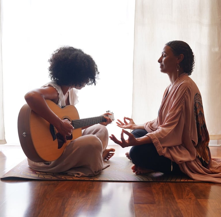 a woman sitting on a mat with a guitar and a guitar