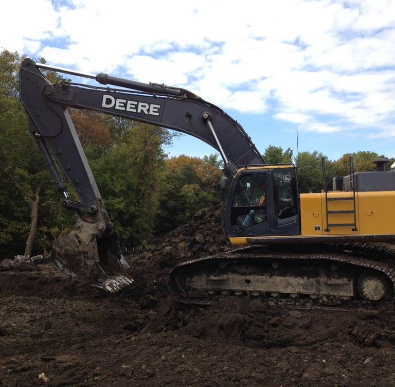 John Deere Excavator digging up dirt
