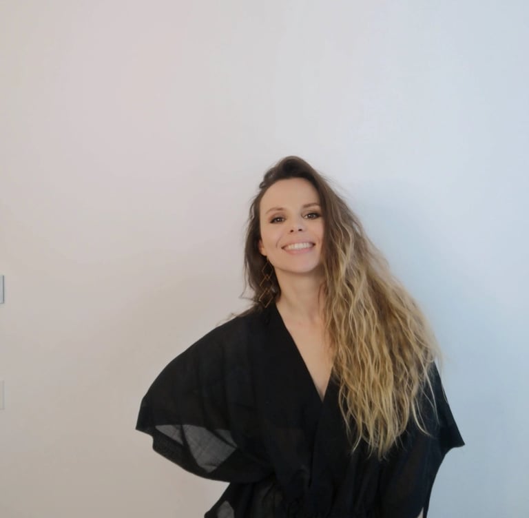 Christine Hauser, RTT Practitioner, smiling warmly in a black kimono top against a white background
