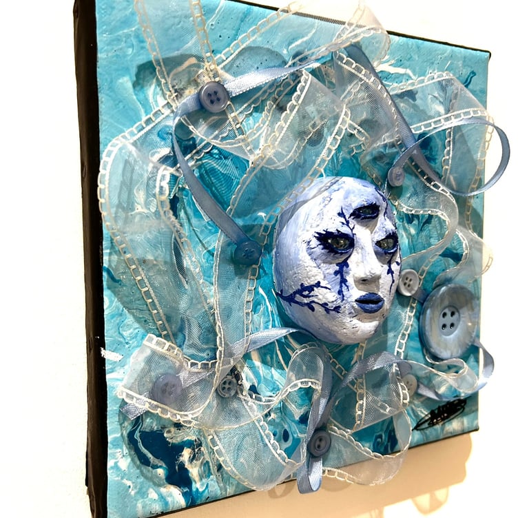 Ilona Paris tableau d'une sculpture d'un visage bleu avec trois yeux et du tissu autour