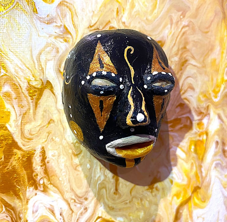 uns sculpture noir ressemblant à un masque qui émerge d'un tableau jaune vu de près