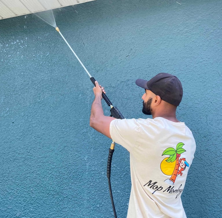 Mop Monkeys technician pressure washing stucco house in Calgary 