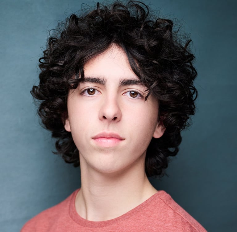 a man with curly hair and a red shirt headshot