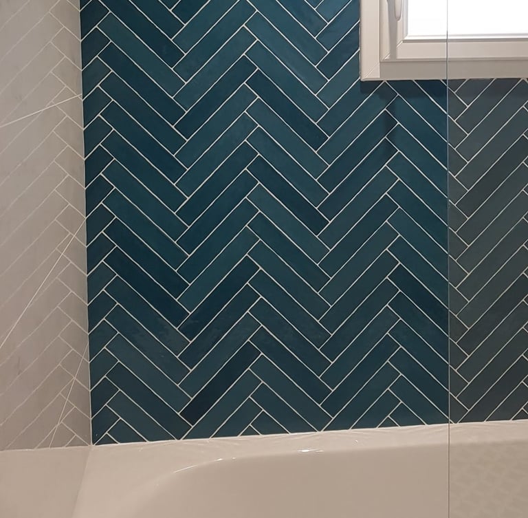 Jolie faïence verte, petites format posé en chevron autour d'une baignoire