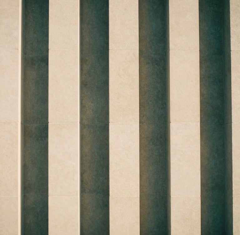 Abstract architectural structure of interlocking stone pillars, clean lines, casting soft geometric shadows on a warm ivory wall, minimalist fine art photography, 35mm