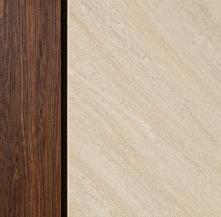Macro detail shot of a high-end material pairing, showing a slab of honed warm travertine meeting a custom deep espresso oak panel, soft natural side lighting, architectural interior photography.