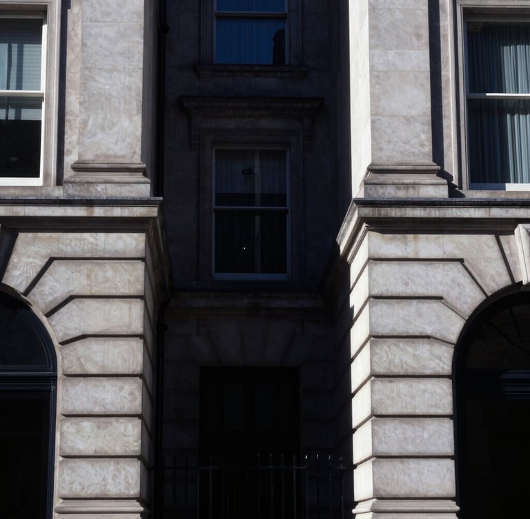Sharp architectural crop of Regent Street stone facades, high-contrast directional daylight, deep navy shadows, 35mm photography