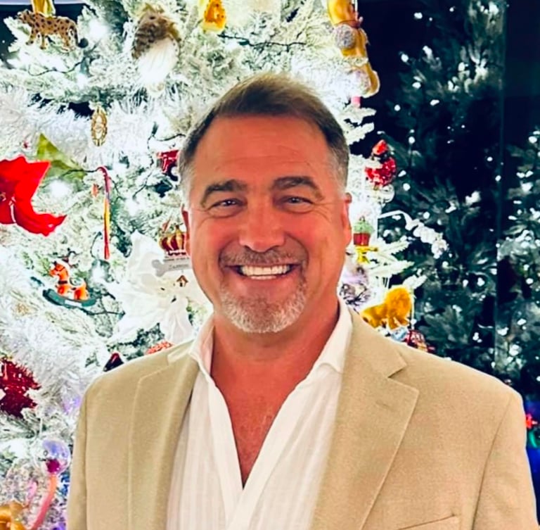Smiling man in a tan blazer.