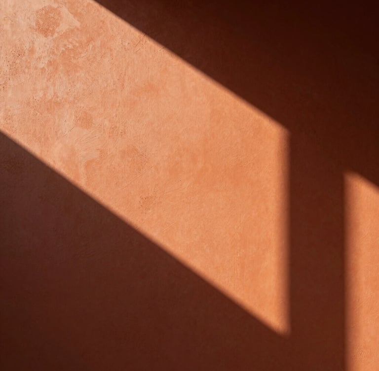 Close-up of premium warm terracotta wall texture, soft morning light casting geometric shadows, minimal luxury atmosphere, architectural detail, 35mm photography