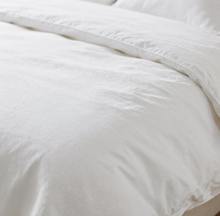 Macro shot of premium white cotton bedding weave, showcasing fine thread density and elegant texture, soft natural lighting, shallow depth of field