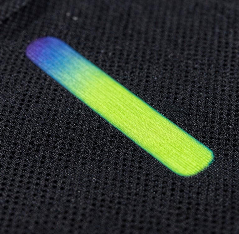 Extreme close-up of neon volt sublimation ink fusing into black athletic fabric, showing the intricate moisture-wicking pore structure.