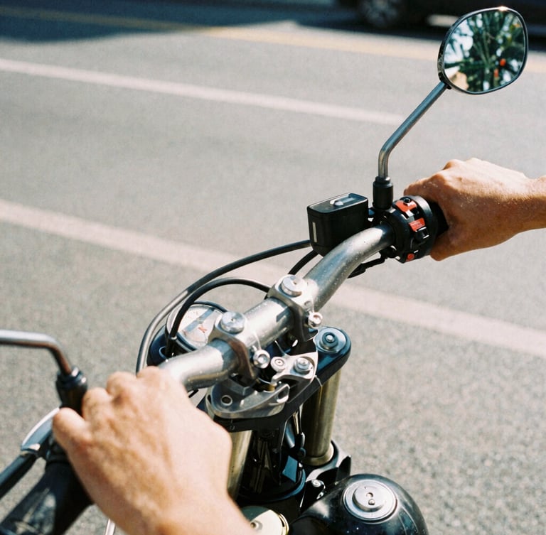 Close-up of hands on motorcycle handlebars, gritty urban street background, daylight, high-contrast warm tones, 35mm