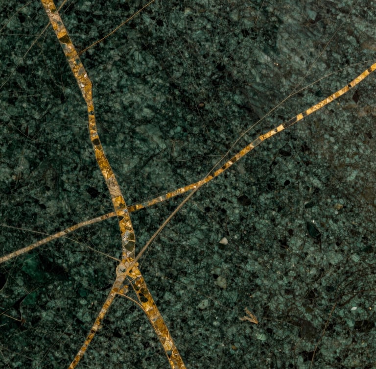 Macro close-up of premium dark green marble slab with natural gold veins, dramatic side lighting highlighting the polished texture, rich warm tones, editorial photography