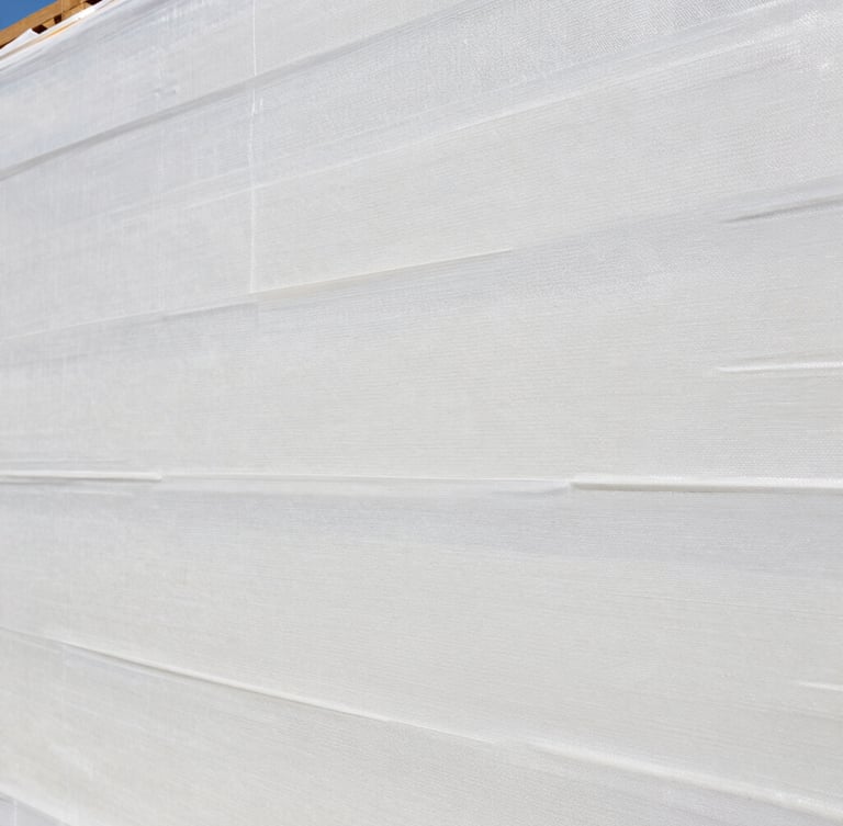 A close-up shot of an EIFS certified professional applying a smooth base coat over a clean moisture barrier mesh, bright daylight, realistic texture.