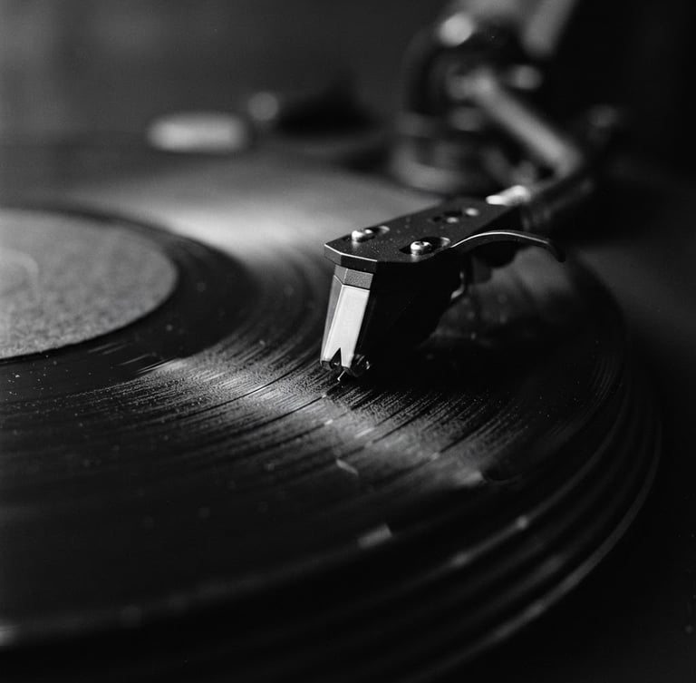 Macro photograph of a vinyl record groove spinning on a high-end turntable, moody low-light studio setting, high contrast black and white, 35mm