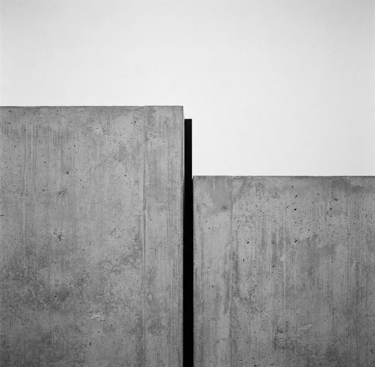 Straight-on orthographic crop of a minimalist black and white architectural photograph, showing sharp concrete lines and fine silver halide grain, diffused gallery lighting.