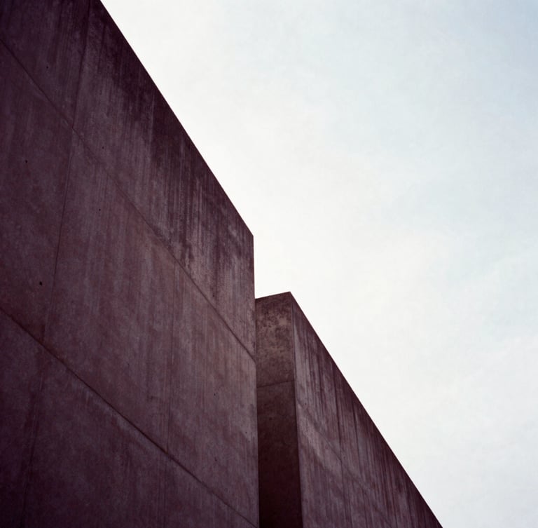 Minimalist architectural lines, sharp concrete angles against a bright sky, dramatic deep mauve shadows, high-contrast editorial composition
