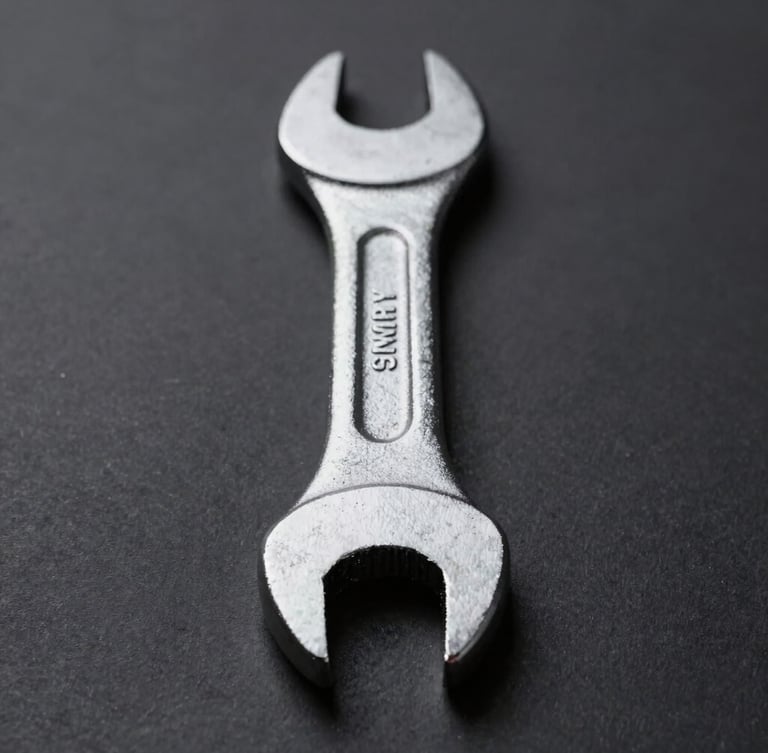Straight-on structural profile of a heavy-duty forged steel wrench, pristine metallic texture, deep charcoal background, sharp directional studio lighting, 50mm macro shot