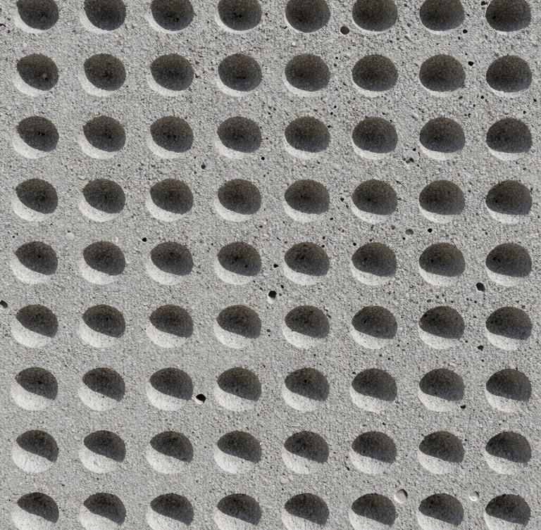 Macro technical photography of a concrete foam cell matrix, showing the uniform air bubble structure inside the gray concrete, harsh direct sunlight highlighting the porous texture, straight-on technical shot.