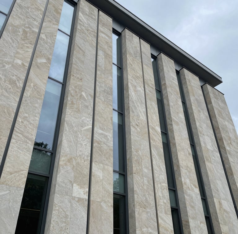 Extreme wide-angle architectural composition of a limestone facade under overcast daylight, clean vertical glass lines, minimalist structural steel.