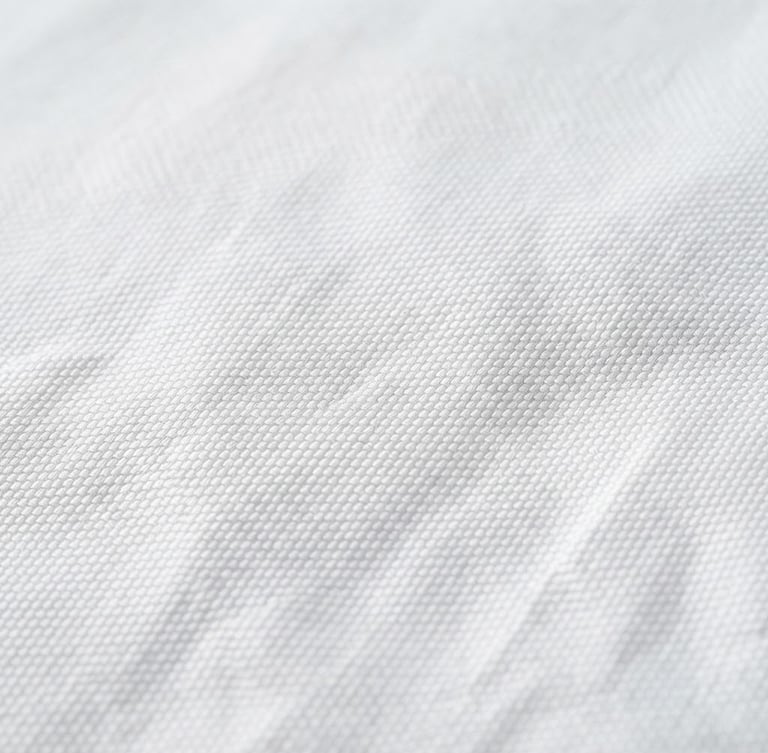 Macro photograph of crisp white high-thread-count hotel bedsheets, sharp textile weave, bright neutral daylight, clean slate gray shadows