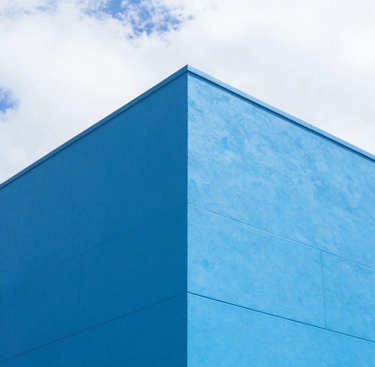 Sharp architectural angle of a modern commercial building exterior with clean electric blue coatings under bright Florida sun