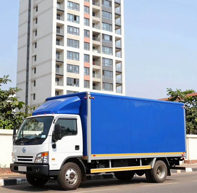 A pristine royal blue and white moving truck parked outside a modern high-rise residential tower in Bangalore, bright daylight, 35mm lens.