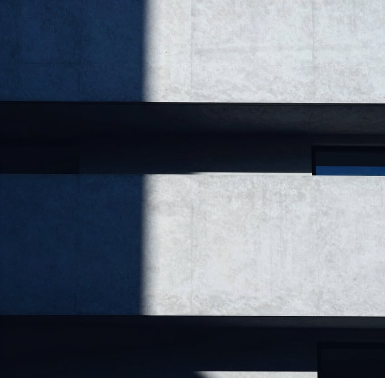 Minimalist architectural crop of a modern concrete building facade, sharp high-contrast studio light, deep indigo shadows, clean lines, 35mm lens