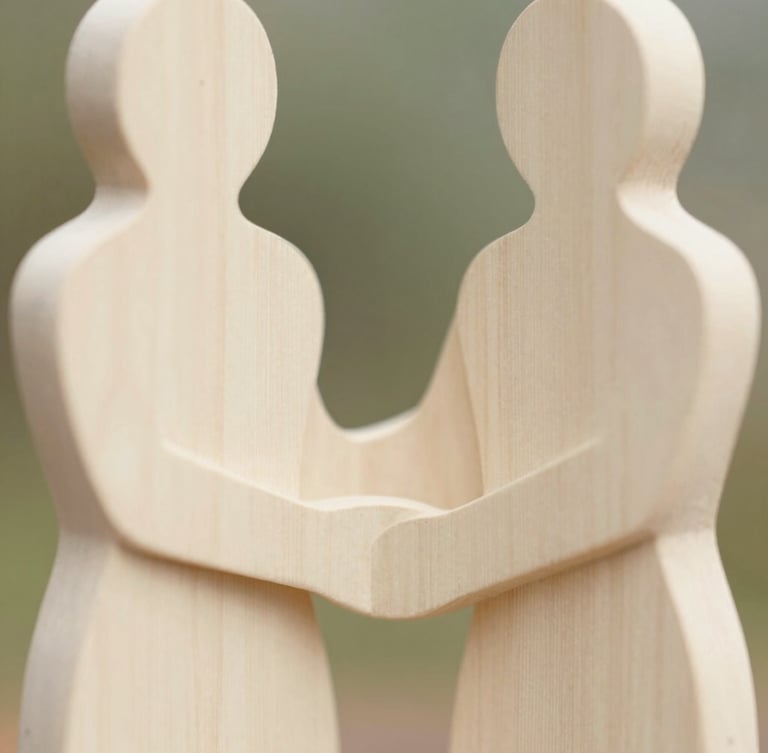 Close-up of abstract, hand-carved wooden figure with soft, organic lines, representing human connection, in warm ivory tones, soft natural daylight, shallow depth of field.