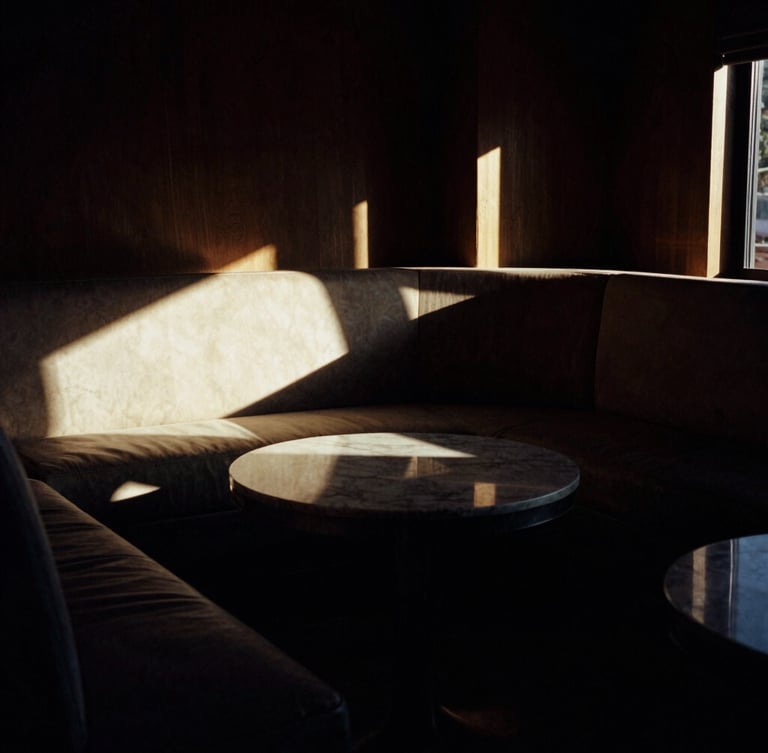 A tight, high-contrast chiaroscuro photograph of a luxurious, empty Phoenix lounge interior, golden hour light cutting through dark shadows, 35mm film.