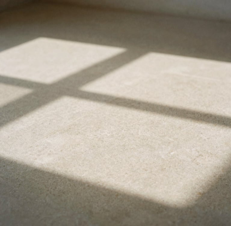 Minimalist close-up of abstract geometric shadows cast on a textured stone surface, soft natural window light, warm neutral tones, high negative space, 35mm